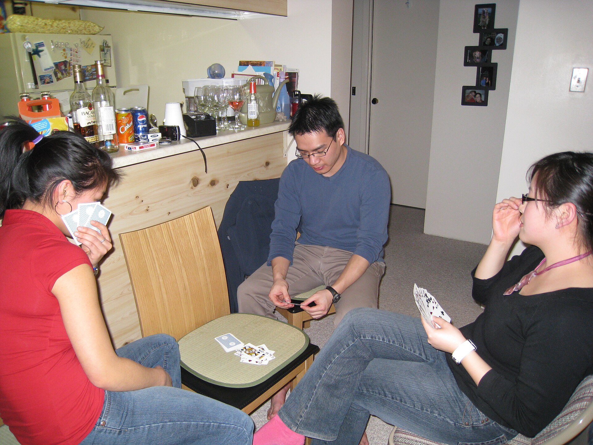 Friends seated around a table playing cards